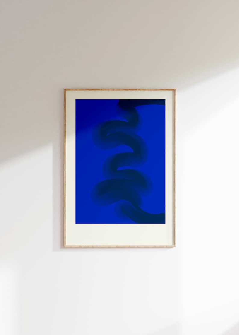 May include: A framed abstract art print with a dark blue, swirling design on a bright blue background.