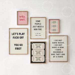 May include: A set of eight framed prints with various humorous sayings and ticket designs. The prints are in black and white with pink and gold accents. The sayings include "Well Shit", "Some People Just Need A High Five", "Let's Play Fuck Off You Go First", "I Do Not Have Ducks. I Do Not Have A Row. I Have Squirrels And They Are At A Rave", and "The Shit Show Admit One".