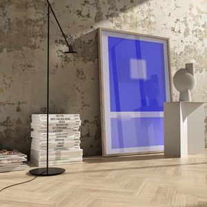 May include: A stack of books with the names of famous architects on the spines, a black floor lamp with a white ceiling, a white pedestal with a white abstract sculpture, and a framed blue poster on a white wall.