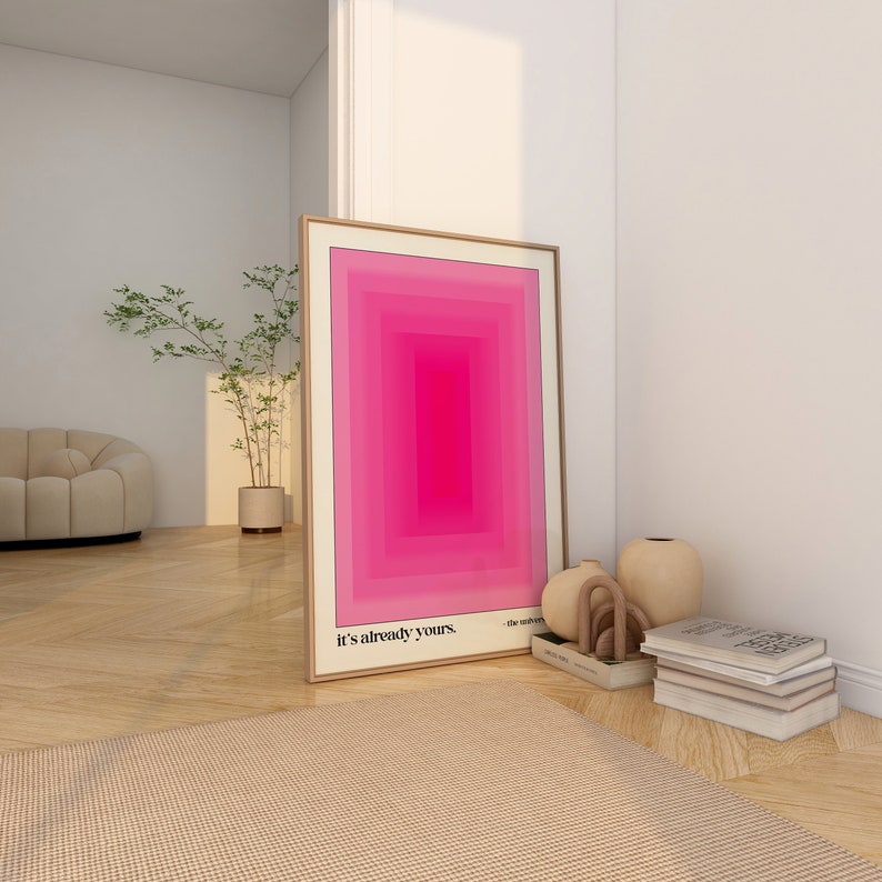 May include: A framed abstract art print with a pink and white geometric design. The print is in a wooden frame and has the text "it's already yours." at the bottom.