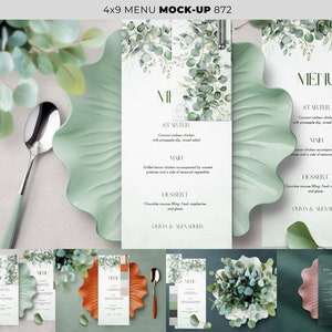 May include: A mockup of a wedding menu card with a green watercolor eucalyptus design. The menu card is on a green plate with a silver spoon. The text on the menu card reads "MENU", "STARTER", "MAIN", "DESSERT", "OLIVIA & ALEXANDER".
