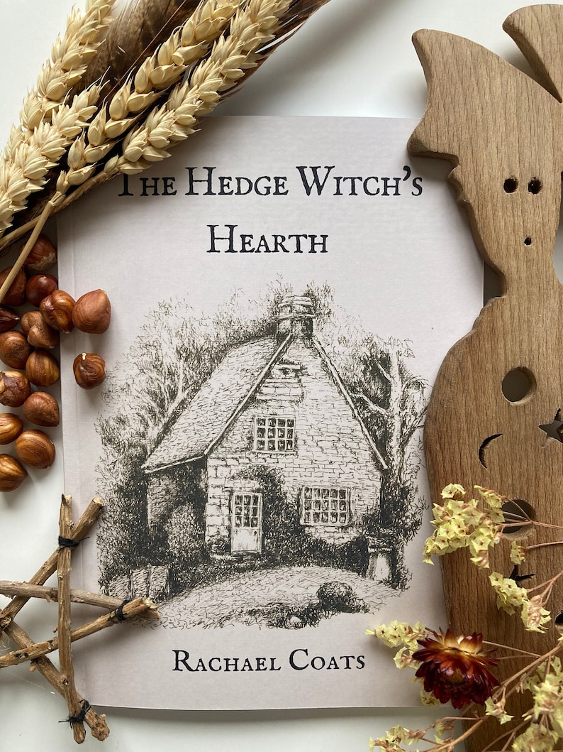May include: A book cover with a drawing of a house and the title "The Hedge Witch's Hearth" by Rachael Coats.