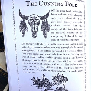 May include: Black and white illustration of a skull with feathers and a cottage in a forest. The text "The Cunning Folk" is at the top of the image. The text below the image reads "And further still where the path becomes no longer a path but a slightly more trodden-down way through the ferns and undergrowth. In the cottage surrounded by trees so thick, from some angles you would only know it was there by the trail of smoke curling steadily upwards from a half hidden chimney. Here is where the fairy tale witch can be found. The wise woman of folklore and myth. The healer whose story was told to the children and the children's children and who still lives within our hearts today, if we only know where to look."