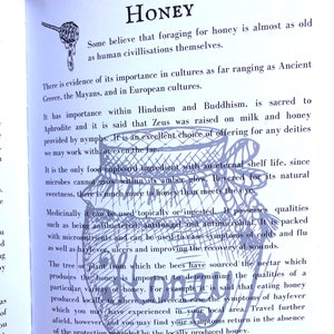 May include: A page from a book about honey, with an illustration of a honey pot and a bee. The text discusses the history and medicinal properties of honey, mentioning its use in ancient cultures and its antibacterial and antifungal qualities.