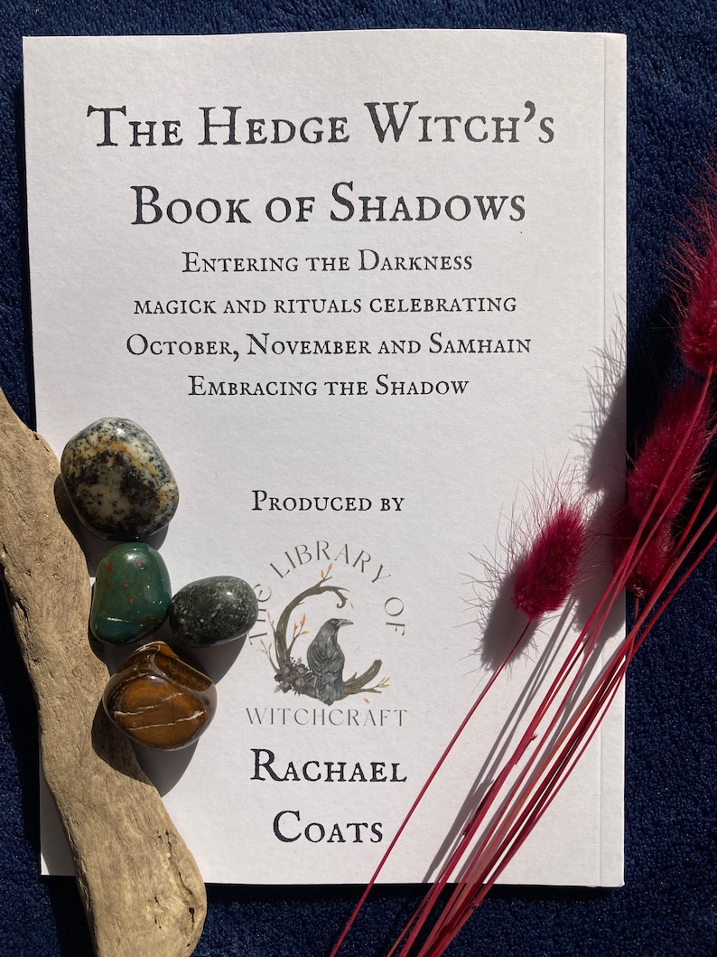May include: A white book with the title "The Hedge Witch's Book of Shadows: Entering the Darkness, Magick and Rituals Celebrating October, November and Samhain, Embracing the Shadow." The book is produced by "The Library of Witchcraft" by Rachael Coats.