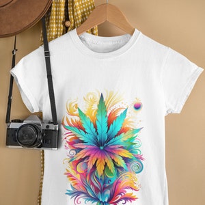 May include: White t-shirt with a colorful graphic of a marijuana leaf surrounded by swirls and abstract shapes.