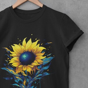 K&ouml;nnte beinhalten: Schwarzes T-Shirt mit einem bunten Grafikdruck eines Sonnenblumenmotivs mit blauen und gelben Farbstichen.