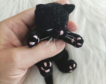 Sleeping black plush kitten, soft pet cat, realistic animal