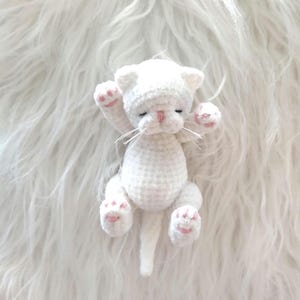 Winzige weiße Mini-Plüschkatze, Miniaturhaustier, realistisches Spielzeugkätzchen
