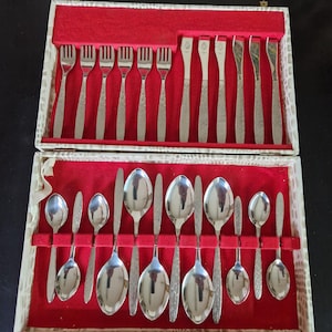 May include: A set of silver cutlery in a red velvet lined box. The set includes forks, spoons, and knives.