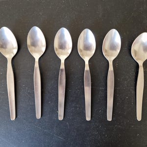 Puede incluir: Seis cucharas de plata con cuencos redondeados y mangos largos y delgados.