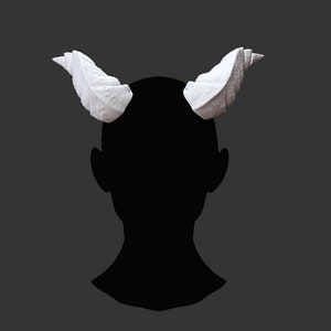 May include: A pair of white, sculpted horns, resembling a spiral shape, are attached to a person's head. The horns are made of a smooth, matte material.