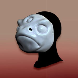 Puede incluir: Una máscara esculpida de color gris claro con una cara de rana, con ojos grandes y redondos y una boca hacia abajo. La máscara está colocada sobre un fondo negro y un fondo degradado rojo-marrón.