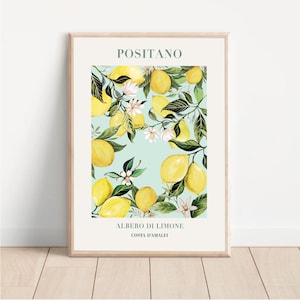 Puede incluir: Una impresión enmarcada con una ilustración de acuarela de un limonero con limones amarillos y flores blancas sobre un fondo azul claro. El texto "POSITANO" está en la parte superior de la impresión y "ALBERO DI LIMONE COSTA D'AMALFI" está en la parte inferior.