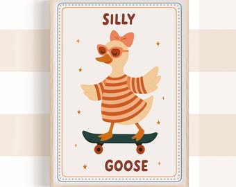 May include: A framed print featuring a cartoon goose on a skateboard. The goose wears sunglasses, a bow, and a striped shirt. The words "SILLY GOOSE" are printed above and below the goose illustration. The print has a light wood frame.