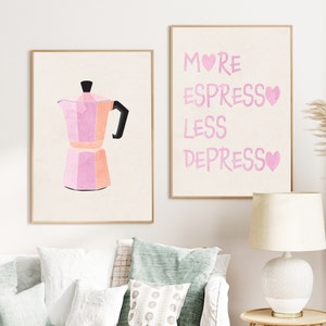 Könnte beinhalten: Zwei gerahmte Drucke in einem rosa-weißen Farbschema. Der linke Druck zeigt eine rosa-weiße Illustration einer Kaffeekanne. Der rechte Druck zeigt den Text "More Espresso Less Depresso" in rosa mit einem rosa Herzen nach jedem Wort.