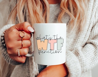 May include: White ceramic mug with the text "What's the WTF function" in black outlined lettering. The letters are filled with different pastel colors.