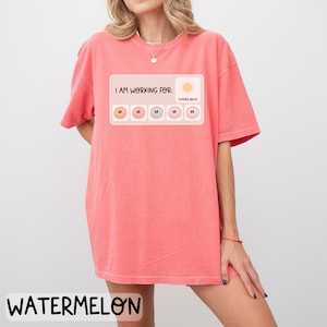 May include: A pink t-shirt with the text "I am working for: Summer Break" and a progress bar with smiley faces. The progress bar is filled with five smiley faces.