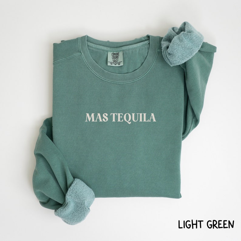 May include: A light green sweatshirt with the text "MAS TEQUILA" printed on the front.