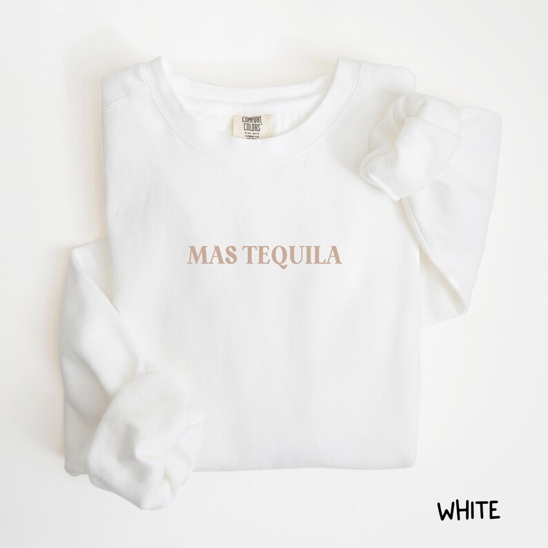 May include: White crewneck sweatshirt with the text "MAS TEQUILA" printed in brown on the front.