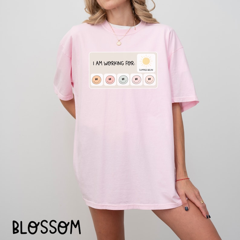 May include: Pink t-shirt with the text "I am working for: Summer Break" and a row of five smiley faces with different colored outlines.