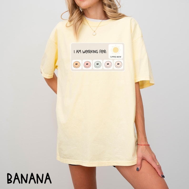 May include: A yellow t-shirt with the text "I AM WORKING FOR: SUMMER BREAK" and a graphic of a sun and five smiley faces.