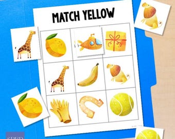 May include: A learning activity sheet titled "MATCH YELLOW" with illustrations of yellow objects, including a giraffe, lemon, submarine, gift, banana, lion, gloves, horseshoe, and tennis ball. The sheet is on a blue folder.