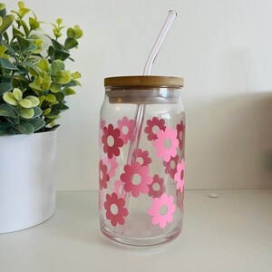 Op bloemen geïnspireerde glazen ijskoffiebekers met bamboe deksels en glazen rietjes.