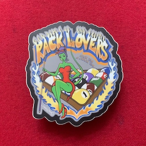 May include: A black and white sticker with a green, red, and blue cartoon woman sitting on a pool table with the text "Rack Lovers" and "Pick 'em up & check 'em out".
