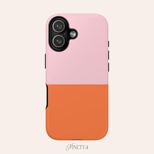 Puede incluir: Funda de teléfono de dos tonos, rosa en la parte superior y naranja en la inferior. Tiene un recorte para la cámara y botones laterales negros. La marca "Ninety4" está impresa en cursiva en la parte inferior.