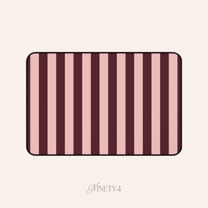 May include: Rectangular object with rounded corners, featuring vertical stripes in alternating shades of pink and burgundy. The object is outlined in black. The word "NINETY4" is written in cursive at the bottom.