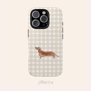 Könnte beinhalten: Eine Handyhülle mit einem Dackel-Design. Die Hülle hat einen beige-weißen Vichy-Muster-Hintergrund. Der Dackel ist braun mit einem weißen Halsband. Die Hülle hat ein schwarzes Kameramodul und schwarze Seitentasten. Das Wort "NINETY4" steht unten.
