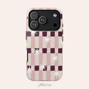 Può includere: Una custodia per telefono con un motivo a strisce rosa alternate e quadrati bordeaux scuro, ornata da stelle bianche. La custodia ha un modulo fotocamera nero e la parola "Ninety4" in corsivo in basso.