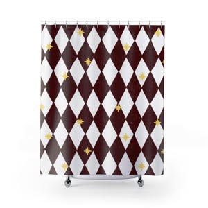 May include: A shower curtain featuring a repeating diamond pattern in dark maroon and white. The design is accented with small, four-pointed yellow stars scattered across the dark maroon diamonds. The curtain hangs from a series of metal rings.