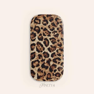 May include: A rectangular case with rounded edges, featuring a leopard print pattern in shades of brown and black. The case has a glossy finish and the text "Ninety4" is at the bottom.