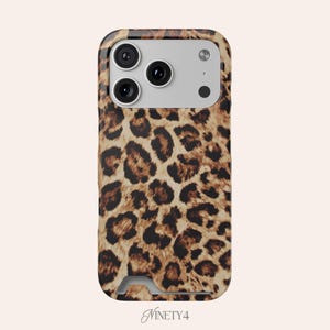 Può includere: Una custodia per smartphone con un motivo leopardato marrone e nero. La custodia presenta un ritaglio rettangolare per il modulo fotocamera, che contiene tre lenti circolari e un flash, e un piccolo ritaglio nella parte inferiore. Il testo Ninety4 è visibile.