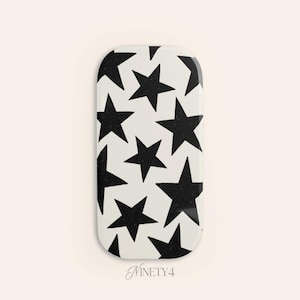 May include: A rectangular, white object with a pattern of black stars. The stars are of varying sizes and are scattered across the surface. The text "NINETY4" is at the bottom.