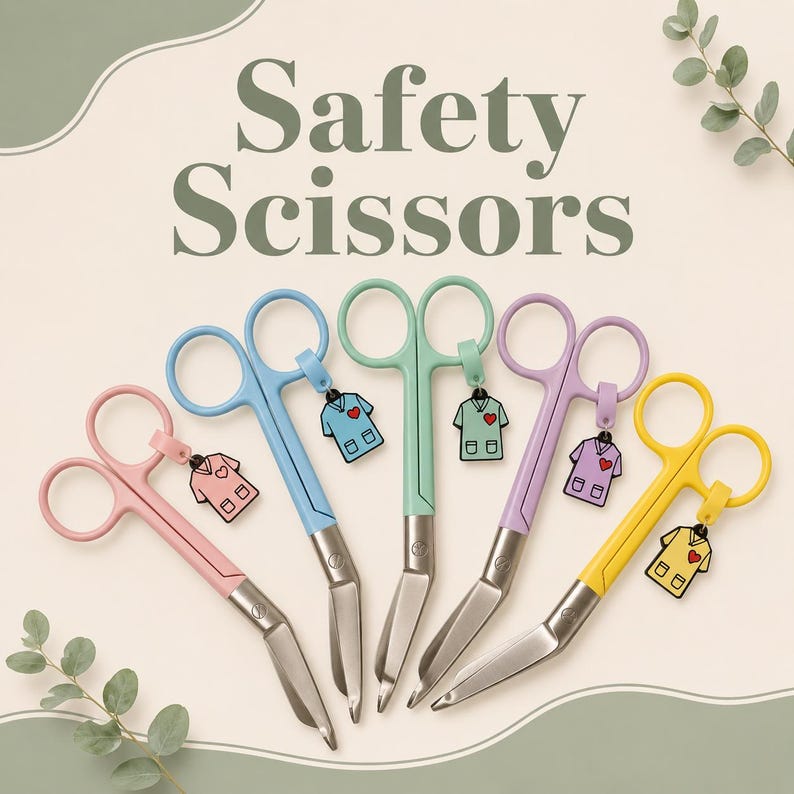 Puede incluir: Cinco pares de tijeras de seguridad con mangos de colores en rosa, azul, verde menta, lavanda y amarillo. Cada par incluye un dije a juego con forma de uniforme m&eacute;dico con un coraz&oacute;n rojo. El texto Safety Scissors aparece en letras verdes.