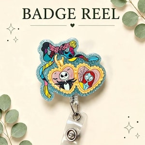 May include: A badge reel featuring a glittery blue acrylic topper with a colourful patterned bow and a gold-toned heart-shaped locket. The locket displays illustrations of Jack Skellington and Sally from The Nightmare Before Christmas.