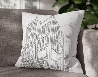 Może przedstawiać: Biała poduszka z czarnym projektem architektonicznym. Poduszka przedstawia szczegółowy rysunek linii nowoczesnego budynku z wieloma oknami i geometrycznymi kształtami. Poduszka leży na szarej sofie.