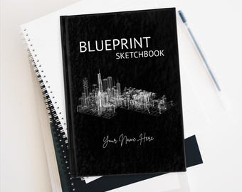 Może przedstawiać: Czarny szkicownik Blueprint z białym projektem linii horyzontu miasta. Okładka zawiera tekst "Blueprint Sketchbook" i "Your Name Here" w odręcznej czcionce. Leży na białym notatniku w spiralnej oprawie.