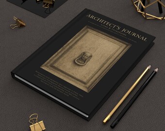 Może przedstawiać: Czarny dziennik zatytułowany "ARCHITECT'S JOURNAL" ze złotymi akcentami, przedstawiający szczegółowy obraz drzwi w stylu renesansowym. Złote spinacze i ołówki są rozrzucone wokół dziennika na ciemnoszarej powierzchni.