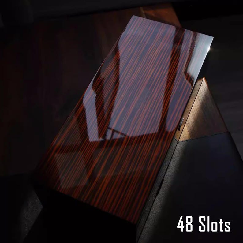 May include: A dark wood box with a glossy finish and a red wood grain pattern. The box has 48 slots and is ideal for storing small items.