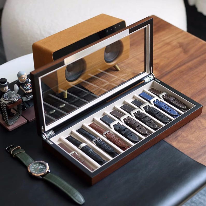 May include: A wooden watch strap storage box with a clear glass lid. The box is open and contains 10 different watch straps in various colours and materials.