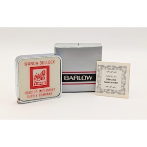 May include: A vintage Tisco tractor implement supply company tape measure with a silver case. The tape measure is next to a silver box with the name "BARLOW" and a small card that says "BARLOW Lifetime Guarantee".
