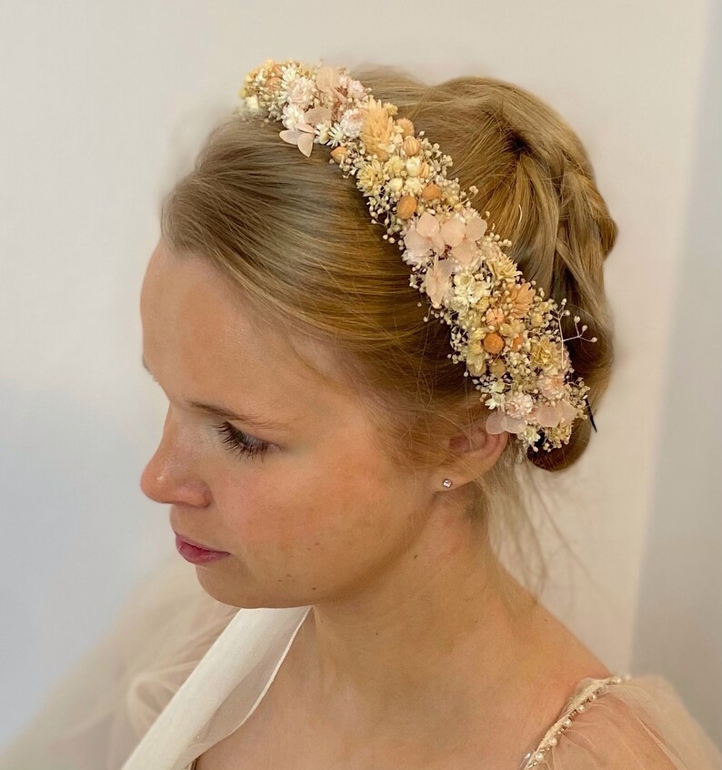 Pode incluir: Uma coroa floral delicada feita de flores secas em tons de creme, p&ecirc;ssego e rosa. A coroa &eacute; perfeita para um casamento ou ocasi&atilde;o especial.