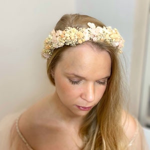 Pode incluir: Uma coroa floral delicada feita de flores secas em tons de p&ecirc;ssego e creme. A coroa &eacute; feita com flores pequenas e delicadas e &eacute; perfeita para um casamento ou ocasi&atilde;o especial.