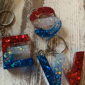 Chaveiro personalizado com letras brilhantes vermelhas, brancas e azuis