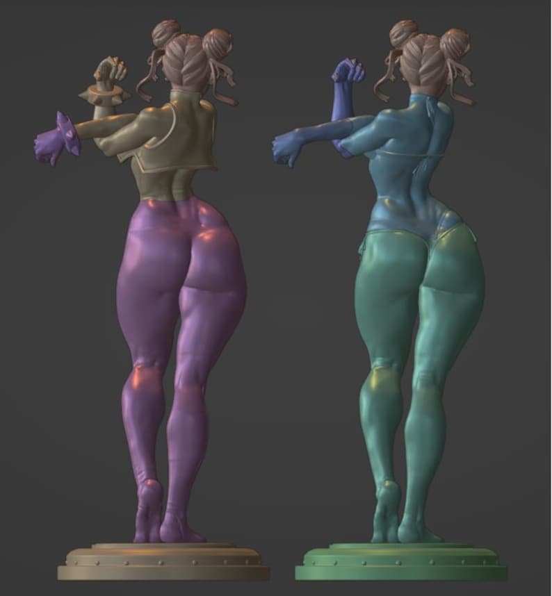 May include: A 3D printed figurine of a female figure with a muscular build, wearing a yellow and purple outfit. The figure is posed with one arm raised and the other arm bent at the elbow. The figure is standing on a circular base.