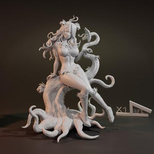 Op de afbeelding: Een wit 3D-geprint beeldje van een vrouw met lang haar en een rankachtig wezen. Ze zit op een boomstam met ranken die uit de basis groeien. Het beeldje is in een neutrale pose, met haar armen rustend op de boomstam.